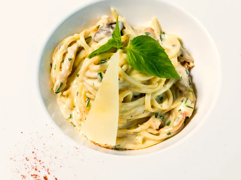 Creamy garlic Parmesan pasta in a pan with fresh herbs and grated cheese